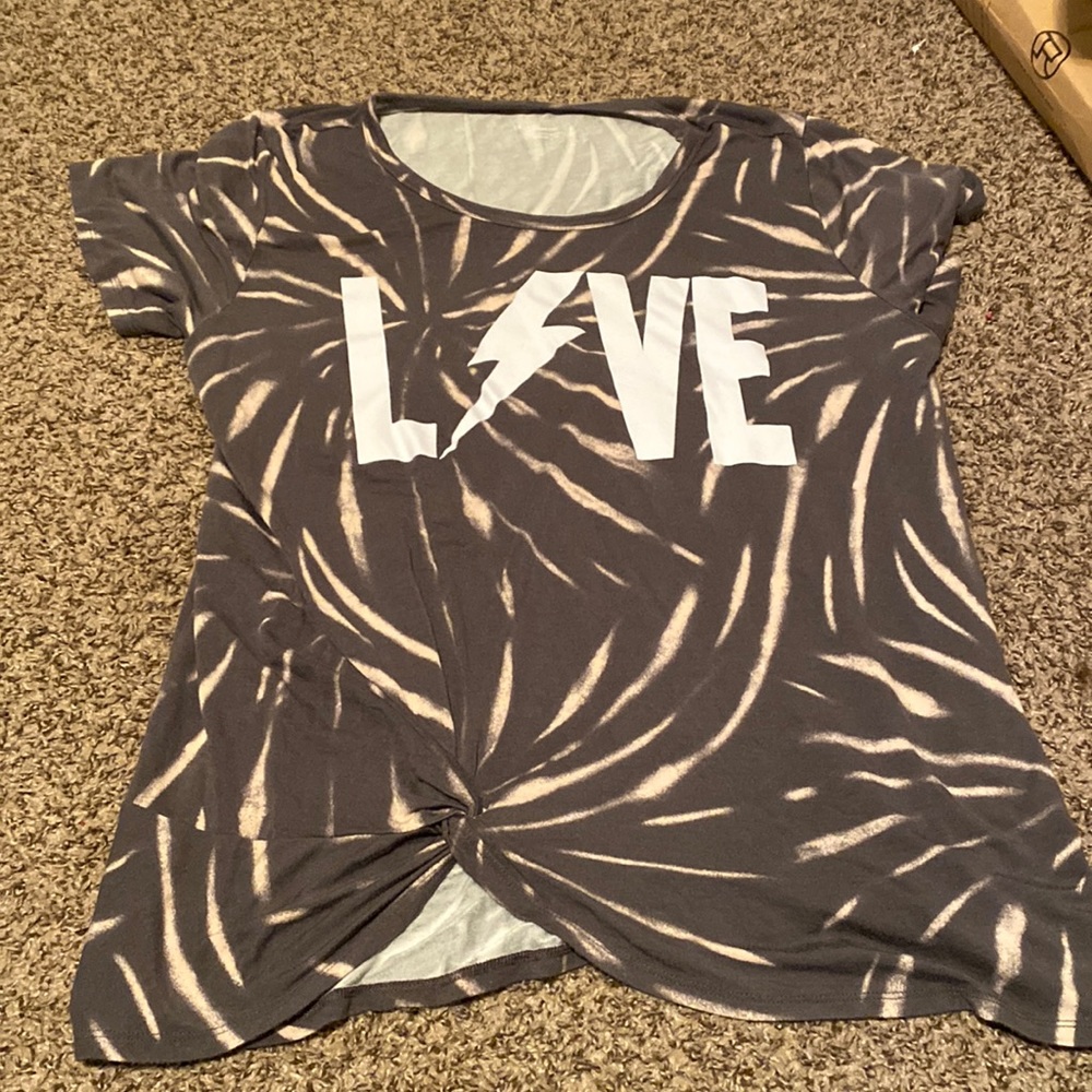 It’s a nice shirt more loose fit it’s longer and has a cute spiral on the left